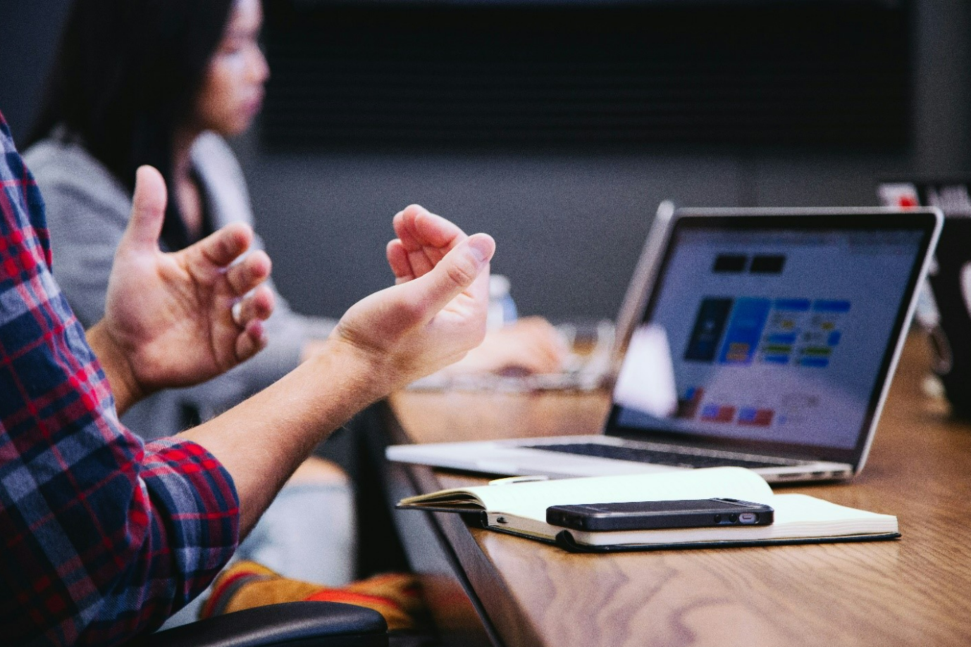 Alt text: Person working at their computer with hands up and near the screen