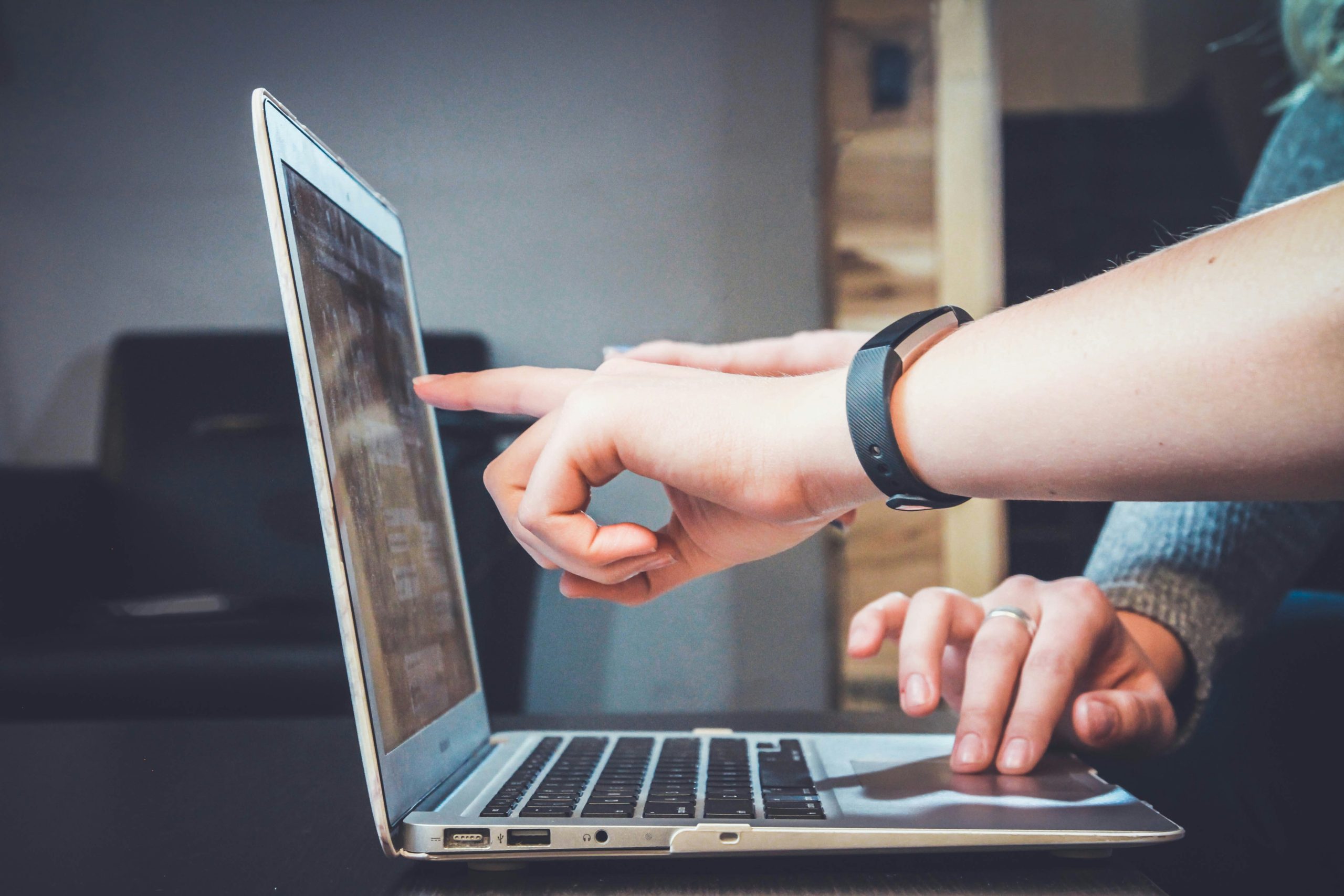 Alt text: Two people pointing at a laptop screen